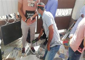 صور.. معلم يساعد طلاب الثانوية العامة بالوادي الجديد على ارتداء الحذاء الواقي