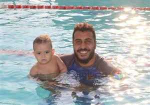 لقبوه بـ"خال العيال".. قصة مدرب الرضع على السباحة في البحيرة - صور