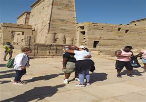 قصة حب وزغرودة بين الآثار.. سائح أمريكي يفاجئ حبيبته داخل معبد فيلة - صور