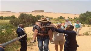 حملها على ظهره 300 متر.. مرشد سياحي ينقذ سائحة أصيبت بضربة شمس في أسوان (صور)