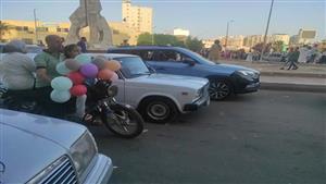 على موتوسيكل.. أسرة توزع بالونات العيد على المواطنين بشوارع البحيرة (صور)