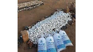 شاب يضع الثلج على قبر والدته للتبريد عليها من حر الصيف