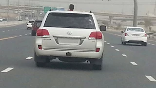 خطر على الطريق.. ضبط سيدة سمحت لنجلها بالجلوس أعلى سقف السيارة بالجيزة