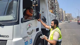 بالصور- توزيع زجاجات مياه على عمال النظافة بشوارع الإسكندرية