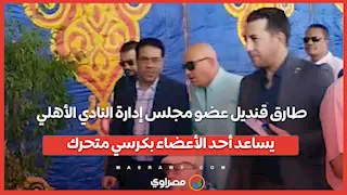 طارق قنديل عضو مجلس إدارة النادي الأهلي يساعد أحد الأعضاء بكرسي متحرك