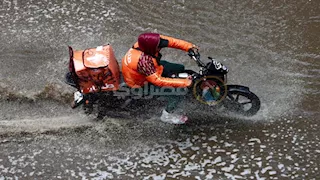 طيارو الدليفري يتحدون الطقس السيئ في شوارع المهندسين