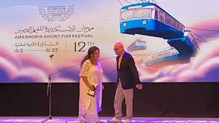 خيري بشارة يسلم منى ربيع تكريمها في مهرجان الإسكندرية للفيلم القصير 