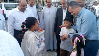 بمناسبة العيد.. محافظ أسوان يوزع كروت تهنئة السيسى والعيدية على الأطفال- صور