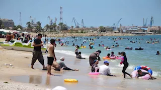   بالصور.. شاطئ بورفؤاد "كامل العدد" وآلاف المصطافين يهربون من حرارة الجو إلى البحر   